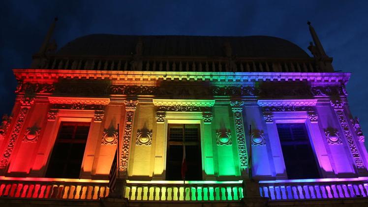 La facciata di Palazzo Loggia illuminata con i colori arcobaleno