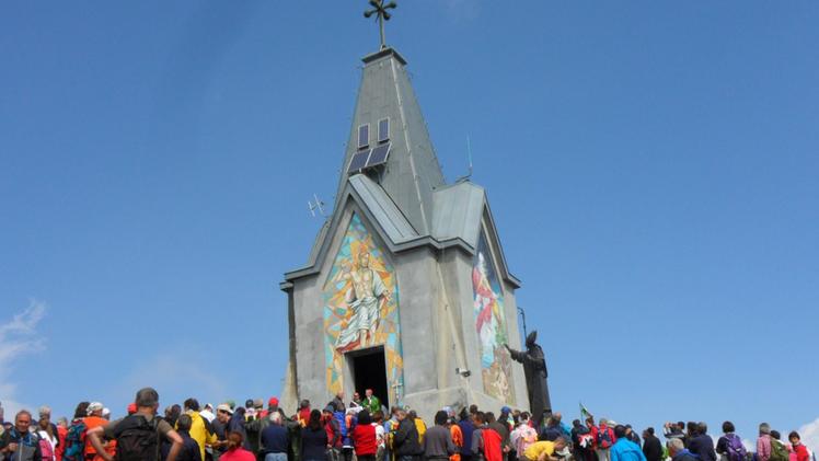 Il monumento e la chiesetta attorniati da decine di visitatori