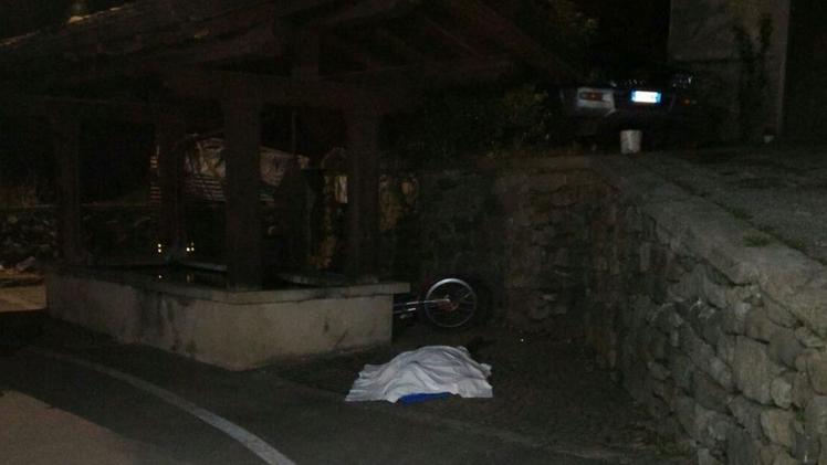 Il corpo senza vita di Adriano Carè coperto da un telo vicino alla fontana: poco distante la sua moto trial