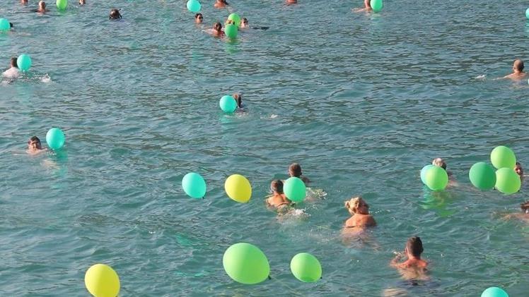 Foto di gruppo con palloncini prima di partire per la traversataI natanti si tuffano nel Golfo