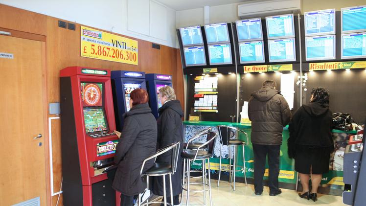 Giocatori e giocatrici alle slot machine
