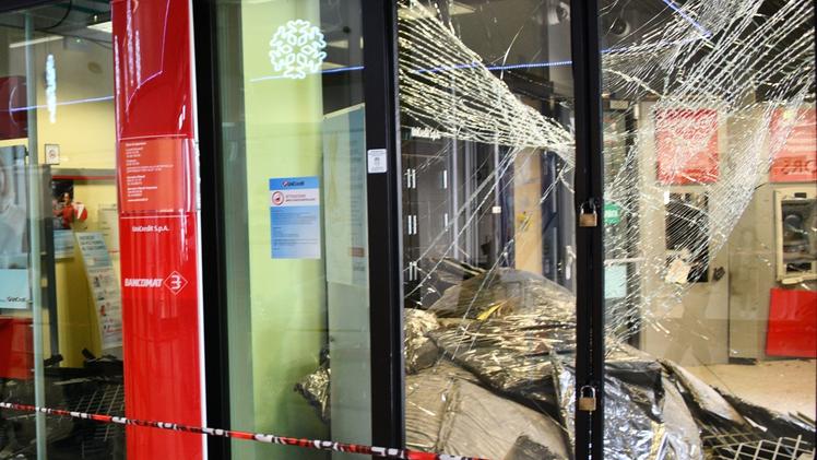 Il vano dell’agenzia in cui si trovano i bancomat e la cassa continuaIl botto nel cuore della notte ha devastato le vetrate e i controsoffitti e danneggiato i negozi del centro
