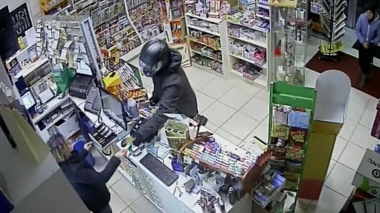 Il bandito, armato del grosso coltello, minaccia la tabaccaiaIl malvivente costringe la proprietaria a consegnare i soldi in cassa