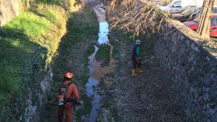 La Protezione civile all’opera   nell’alveo di un piccolo torrente La ripulitura della vasca naturale nella località Varzà