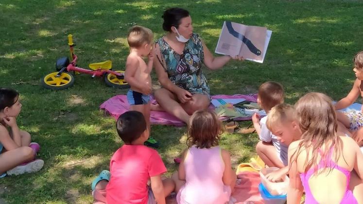 Una istantanea delle letture per bambini in spiaggia organizzate ad Anfo dalla biblioteca