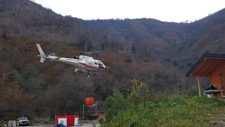 Una istantanea dell’incendio appiccato in Valle DuppoUno degli elicotteri impiegati mentre si rifornisce di acqua