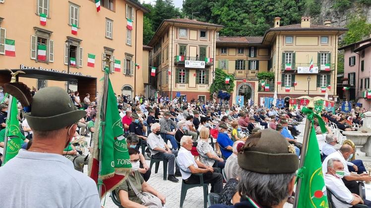 Una veduta d’insieme della piazza Ronchi di Breno durante l’epilogo delle due ricorrenze alpineIl cuore  della cittadina tappezzato di tricolori e animato da centinaia di penne nere