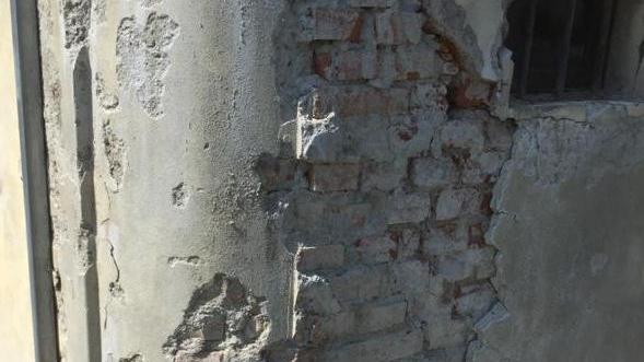 La tenuta di un muro di contenimento è all’origine  delle crepe che si sono prodotte nei muri della sacrestiaLe evidenti crepe  nell’edificio che suscitano preoccupazione