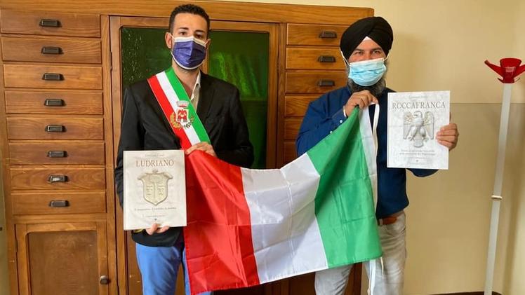 Il sindaco Marco Franzelli e Manjit Singh, neo cittadino italiano,  posano felici con  la bandiera tricolore
