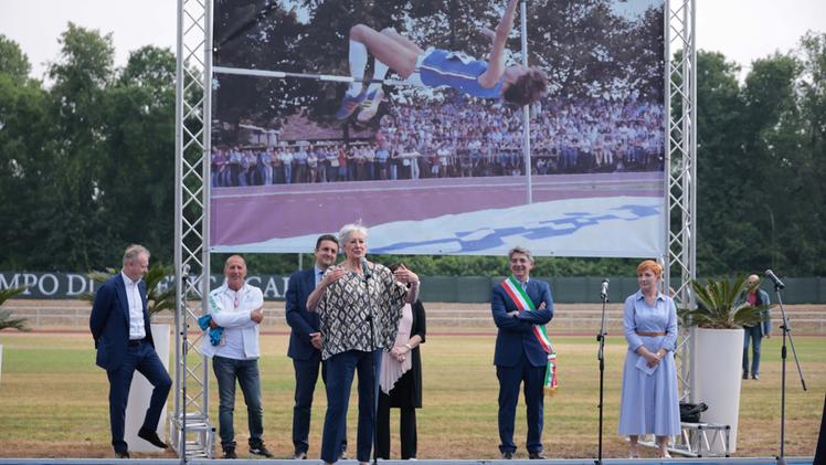 Sara Simeoni con l'immagine del suo salto da record alle spalle
