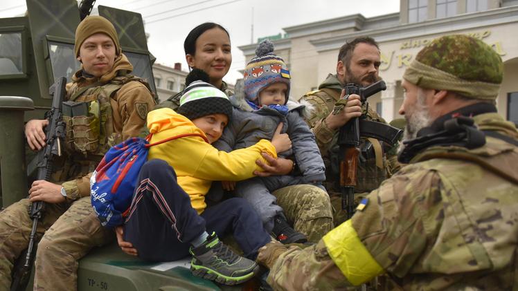 Soldati e bambini nella piazza centrale di Kherson: il 9 novembre la Russia aveva ordinato il ritiro delle truppe dalla città